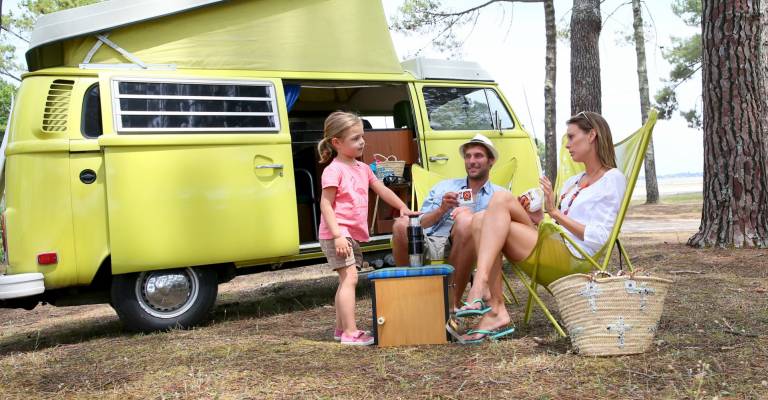 Gezin in bos bij camper